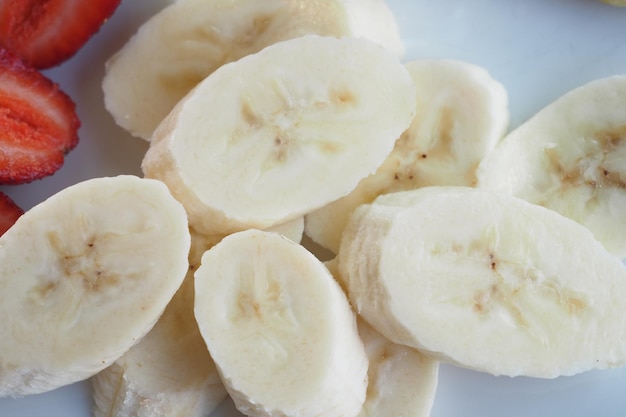 Close up van plakje banaan glas melk op tafel