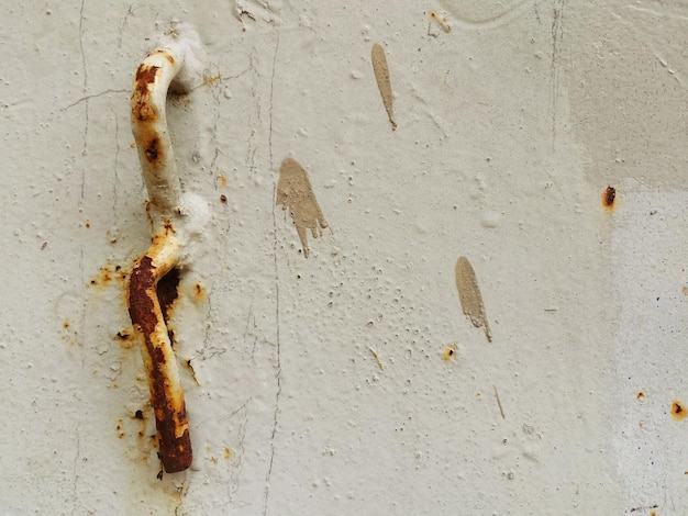Foto close-up van roestige metaal op een verweerde muur