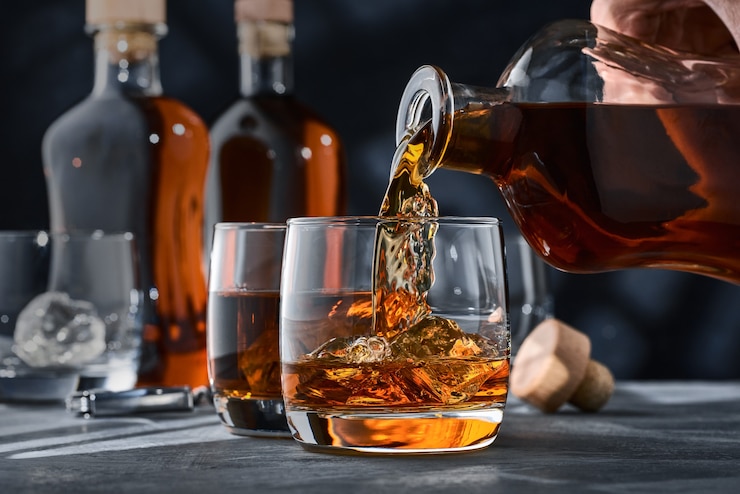 Foto close-up van ronde glazen whisky met ijs op tafel