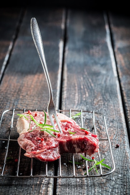 Close-up van rood vlees met rozemarijn en peper