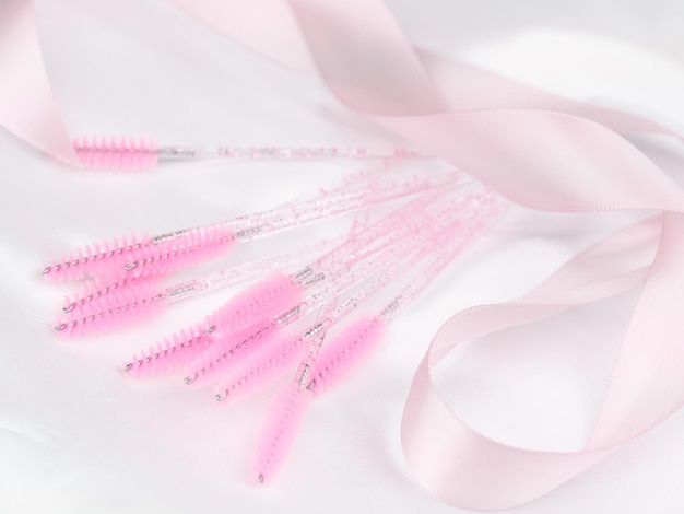 Close-up van roze borstels voor het kammen van wimperverlengingen en wenkbrauwkruk voor behandeling