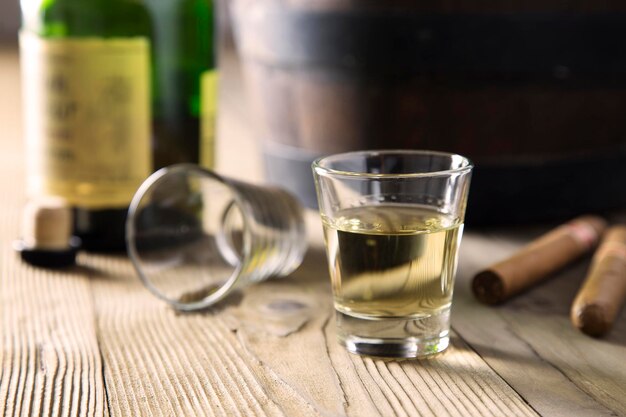 Foto close-up van rum in een glas bij een sigaar op tafel