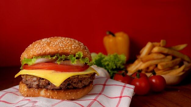 Close-up van rundvlees hamburger met frietjes en ingrediënten op rustieke tafel