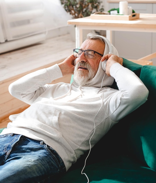 Close-up van senior oudere hipster man met behulp van telefoon tijdens het luisteren naar afspeellijst muziek op mobiele app ouderling