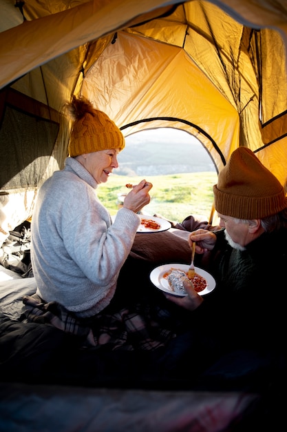 Foto close-up van senioren die in tent eten