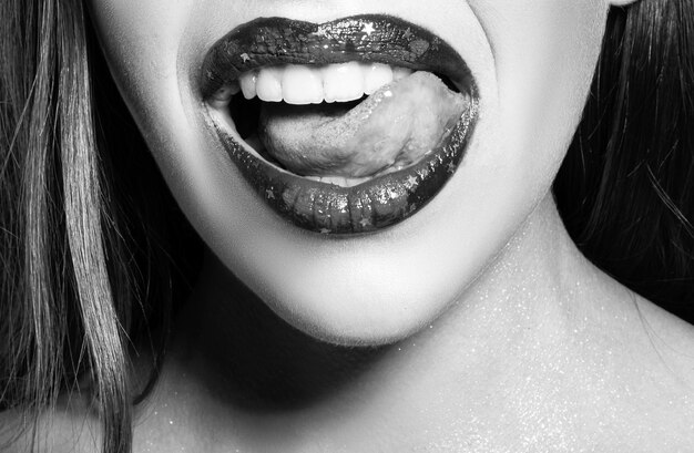 Close-up van sexy open mond met tong likken witte tanden sensuele rode lippen sexy lippen zuigen