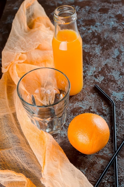 Foto close-up van sinaasappelsap met fruit op tafel