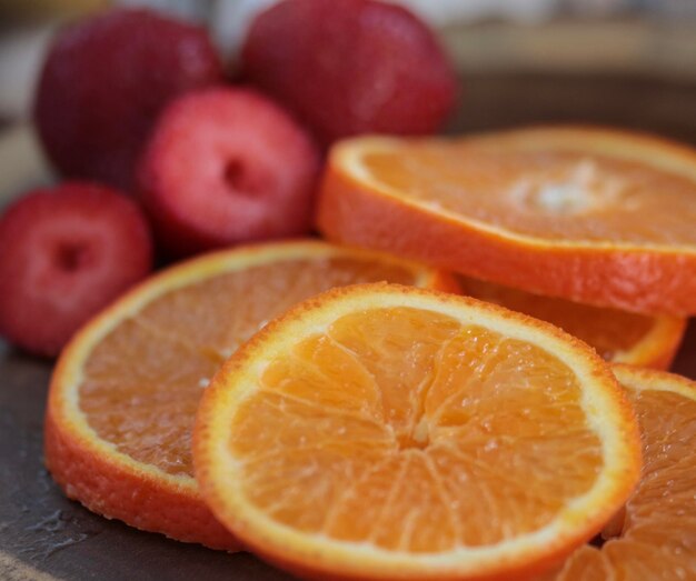 Foto close-up van sinaasappelsnijden op tafel