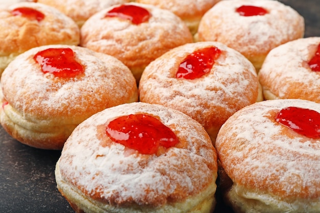 Close-up van smakelijke donuts met jam op donkere achtergrond. Chanoeka viering concept