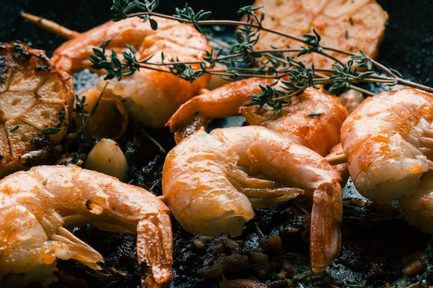 Close up van smakelijke gebakken garnalen zonder kop met tijm takjes en knoflook