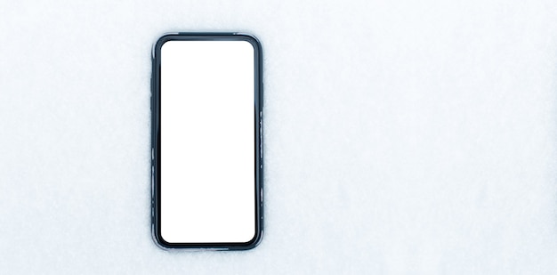 Close-up van smartphone met mockup op achtergrond van sneeuw. Panoramisch banner bovenaanzicht. Ruimteconcept kopiëren.