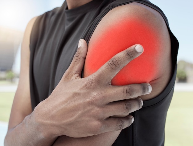 Close-up van sportman die lijdt aan een ontstoken schouderblessure Atletische actieve atleet die zijn pijnlijke arm vasthoudt en wrijft met gloeiende rode cgi Overbelasting van de spieren veroorzaakt spanningskramp of verstuiking