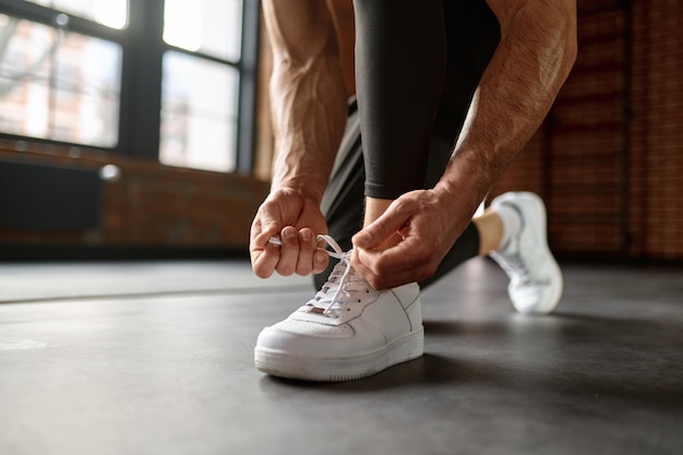 Close-up van sportman die sneakers bindt die zich voorbereiden op training