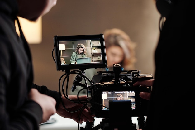 Close-up van steadicam-schermen met vrouwelijk model met laptop aan tafel