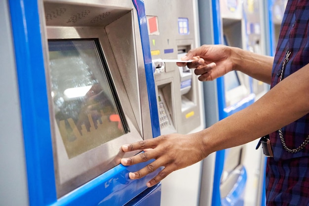 Close up van stijlvolle Afro-Amerikaanse man die terminal gebruikt voor het kopen van een kaartje in de metro