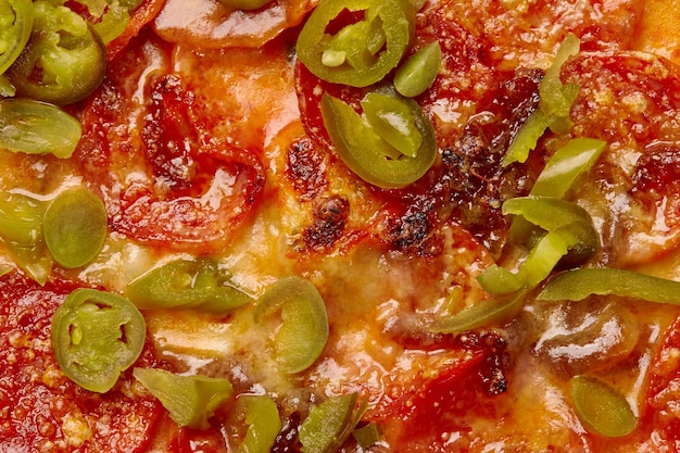 Close-up van stukjes jalapeno pepers op pittige pepperoni pizza