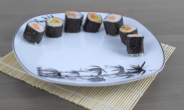 Close-up van sushi en eetstokjes op een witte plaat