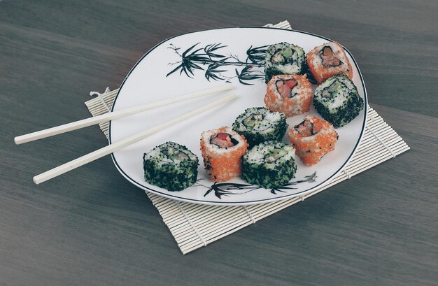Close-up van sushi en eetstokjes op een witte plaat