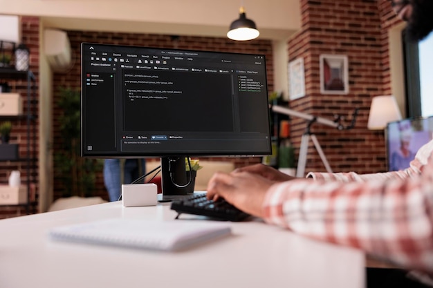 Close-up van systeemontwikkelaar die code schrijft op het typalgoritme van de personal computer op het toetsenbord dat op afstand werkt. Afro-Amerikaanse programmeur codering vanuit huis ontwikkelingssoftware op pc.