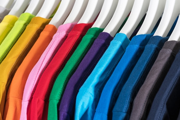 Close-up van t-shirts, kleren op hangers op wit