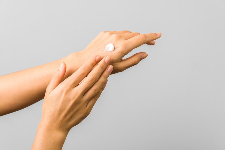Close-up van tedere handen van een jonge vrouw met vochtinbrengende crème. lente huidbescherming