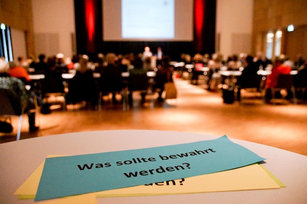 Foto close-up van tekst met mensen die op de achtergrond in het auditorium zitten