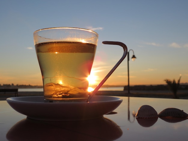 Close-up van thee die tijdens de zonsondergang op tafel wordt geserveerd