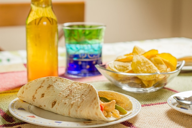 Close-up van traditioneel Mexicaans eten in een tafel, met een bord kip fajita, kom nacho's en een vers biertje