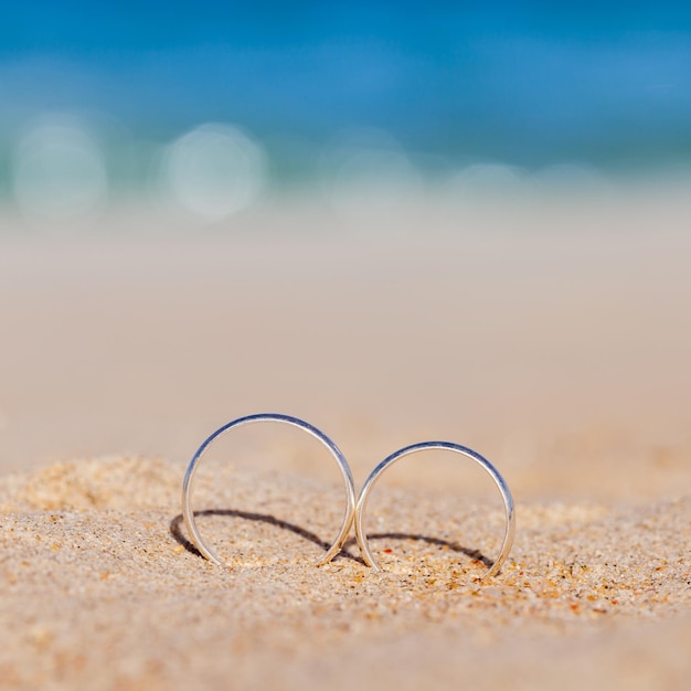 Foto close-up van trouwringen op het zand