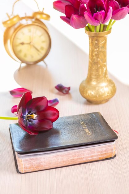 Foto close-up van tulpen in een vaas op boeken aan tafel