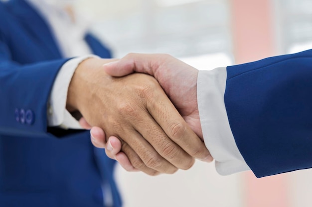 Close-up van twee zakenmensen die elkaar de hand schudden