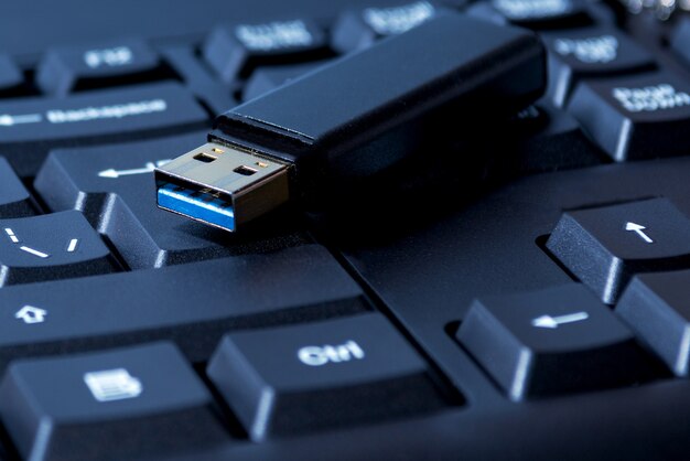 Close-up van USB-geheugenstick die op computertoetsenbord rust