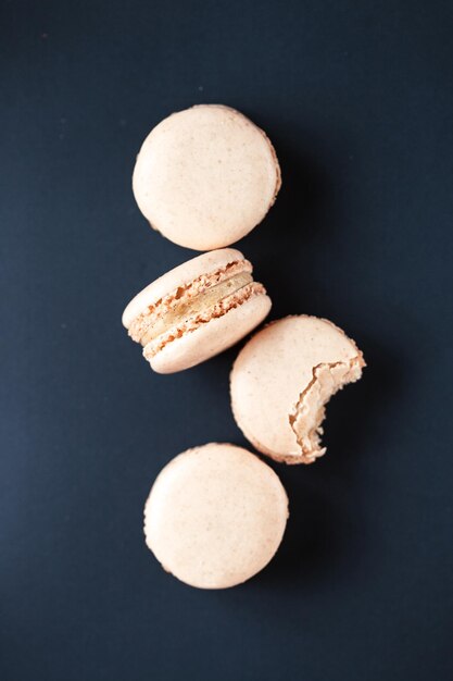 Foto close-up van vanille macaron koekjes tegen een zwarte achtergrond