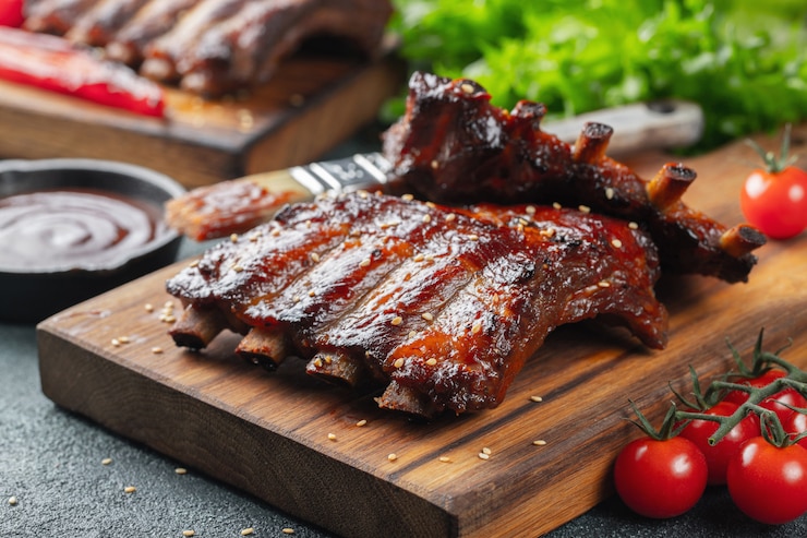 Foto close-up van varkensvleesribben die met bbq saus worden geroosterd