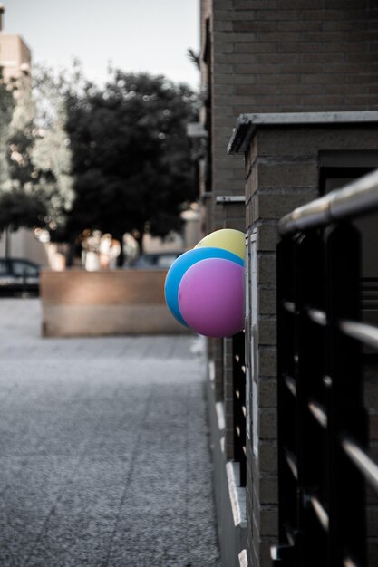 Foto close-up van veelkleurige ballonnen op de weg tegen een gebouw in de stad