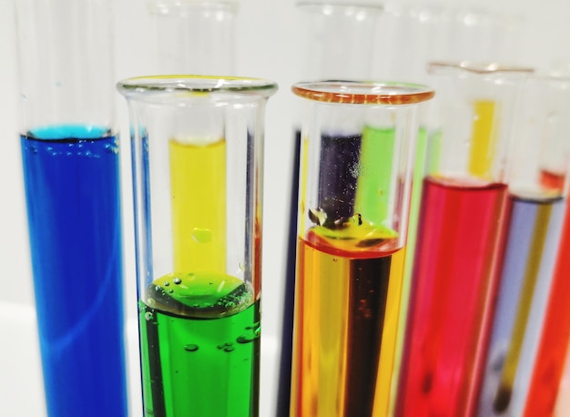 Close-up van veelkleurige chemicaliën in proefbuizen tegen de muur