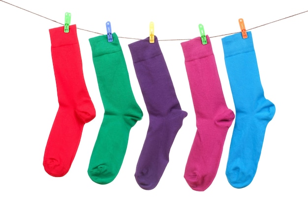 Foto close-up van veelkleurige sokken op waspinnen die op een witte achtergrond hangen