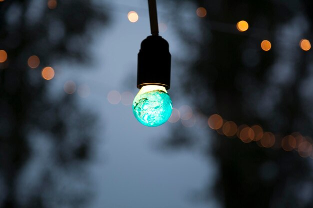 Foto close-up van verlichte verlichtingsapparatuur die's nachts tegen de hemel hangt