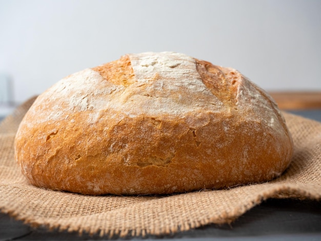 Close-up van vers knapperig rondgevormd tarwebrood op een donkere achtergrond Zijaanzicht