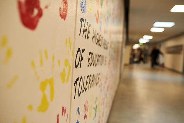 Close-up van verschillende gekleurde handafdrukken op een muur in een school