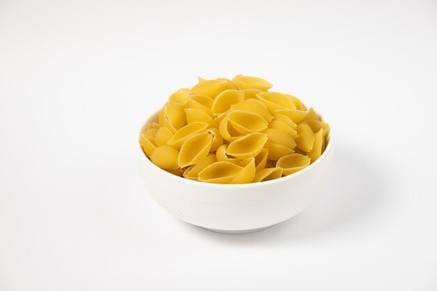 Close up van verschillende soorten droge pasta in een bord op witte achtergrond