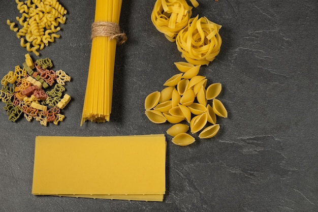 Close up van verschillende soorten droge pasta op donkere achtergrond