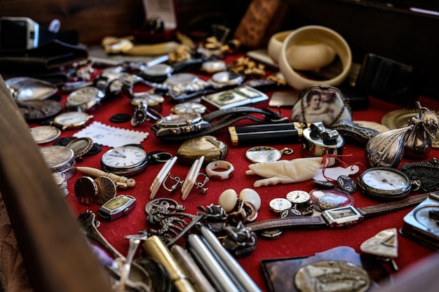 Close-up van verschillende vintage horloges en sieraden op een rode surfa