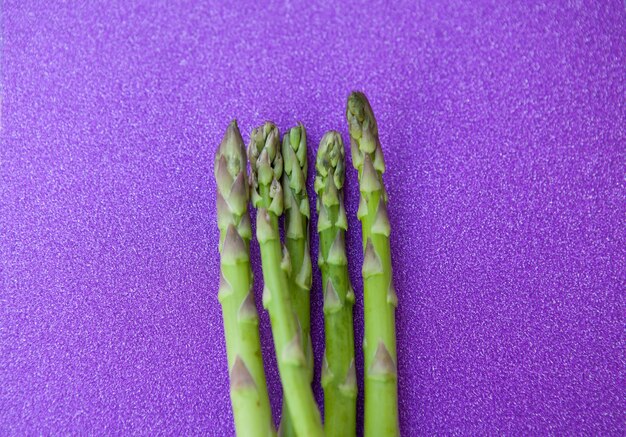 Close up van verse asperges bos op glitter violet background