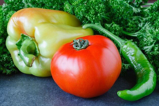 Close-up van verse, rijpe tomaten, paprika en peterselie op hout achtergrond.