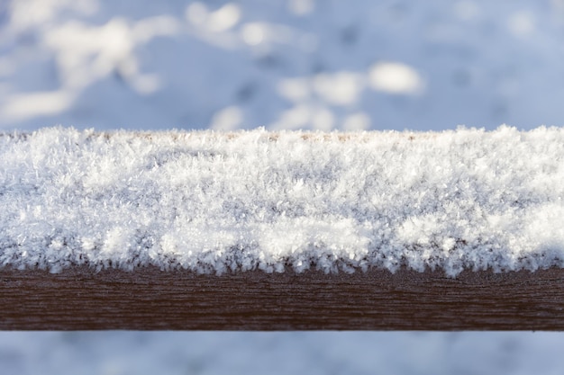 Close-up van vorst en sneeuw op de houten balk