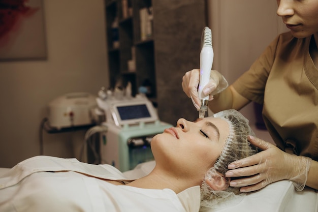 Close-up van vrouw die gezichtsbehandeling hydro microdermabrasie peeling krijgt Vrouw bij cosmetische beauty spa slinic Hydra stofzuiger Cosmetologie