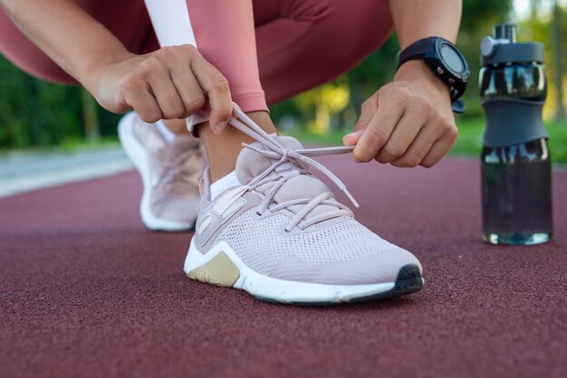 Foto close-up van vrouw die schoenveters bindt vrouwelijke sportfitnessloper die zich voorbereidt op joggen in de open lucht