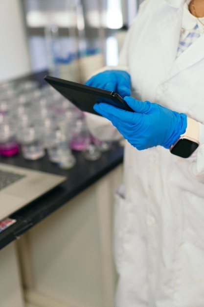 Close-up van vrouw in laboratoriumjas met behulp van Tablet in Lab