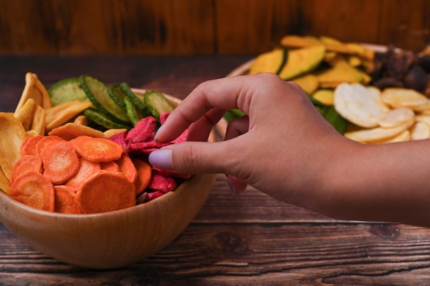 Close-up van vrouw met biologische gedroogde groenten chips.